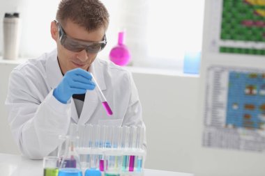 Bir erkek kimyager tüp cam tutar