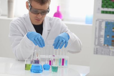 Bir erkek kimyager tüp cam tutar