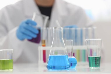 Bir erkek kimyager tüp cam tutar