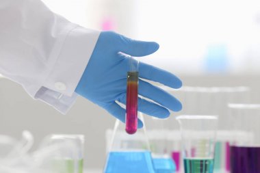 Bir erkek kimyager tüp cam tutar