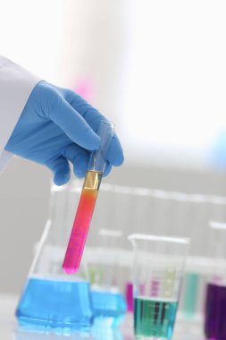 Bir erkek kimyager tüp cam tutar