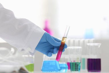 Bir erkek kimyager tüp cam tutar