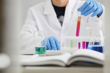 Bir erkek kimyager tüp cam tutar