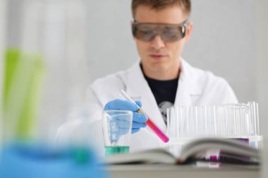 Bir erkek kimyager tüp cam tutar