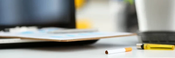 Cigarro e isqueiro deitado à mesa de trabalho — Fotografia de Stock