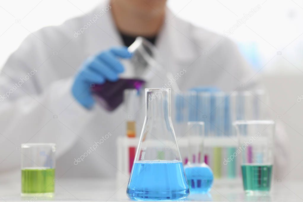 A male chemist holds test tube of glass