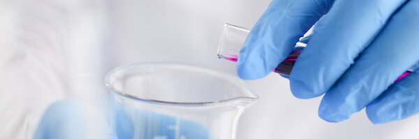 A male chemist holds test tube of glass