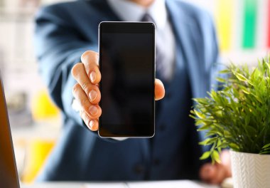 Takım elbiseli erkek kolunu göster kamera telefon ekranını