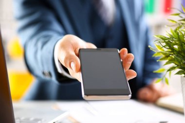 Takım elbiseli erkek kolunu göster kamera telefon ekranını