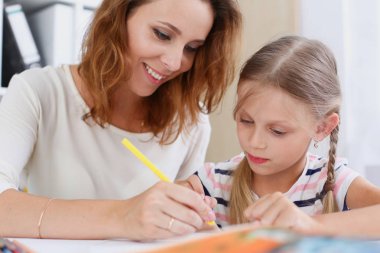 Sarışın küçük kız gülümseyerek kol kalemi tutun