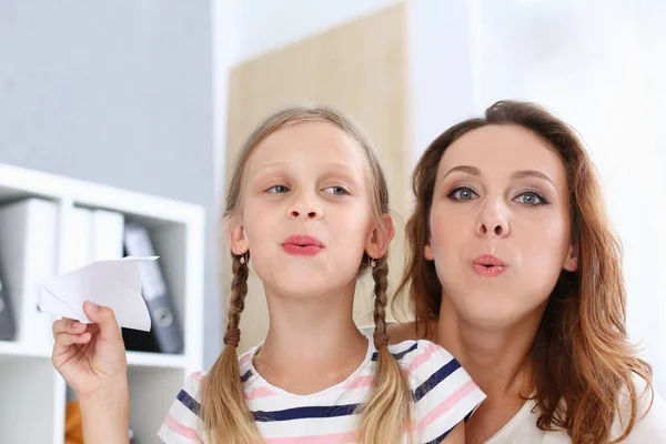 Blondes lächelndes kleines Mädchen bastelt Papierflieger — Stockfoto