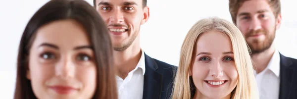 Group of smiling people stand in office