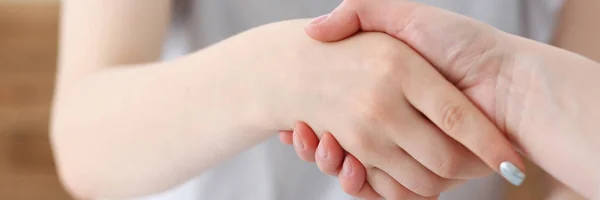 Business woman and woman shake hands