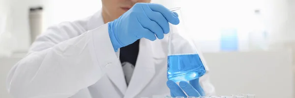 Un químico masculino sostiene tubo de ensayo de vidrio —  Fotos de Stock