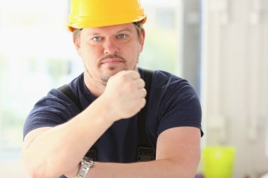 Sarı kask içinde gülümseyen komik işçi