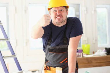 Sarı kask içinde gülümseyen komik işçi