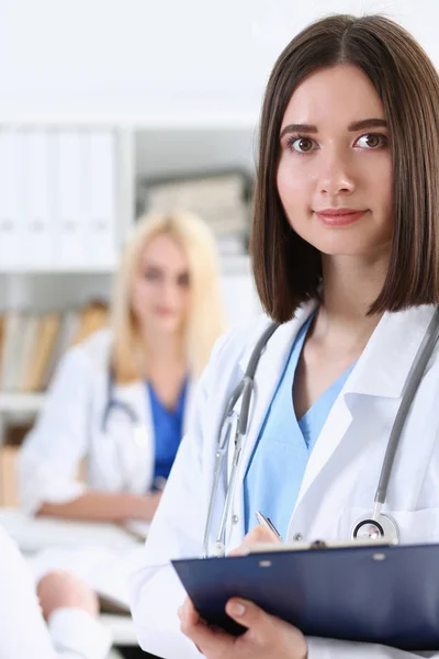 Beautiful smiling female doctor stand in office