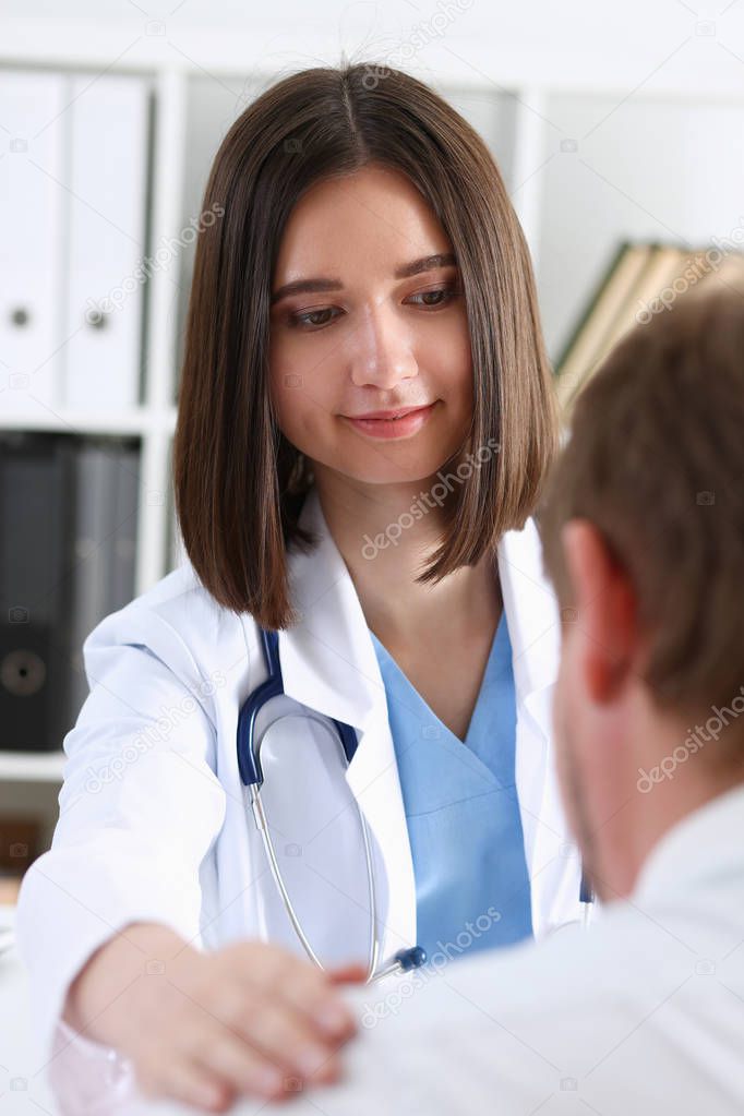 Friendly female doctor hold patient shoulder