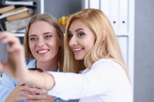 Twee vrouwelijke ondernemers in het kantoor glimlach en doen selfie — Stockfoto