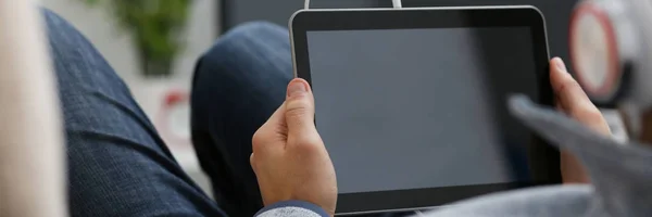 Мужская рука держит планшет в домашних условиях в то время как — стоковое фото