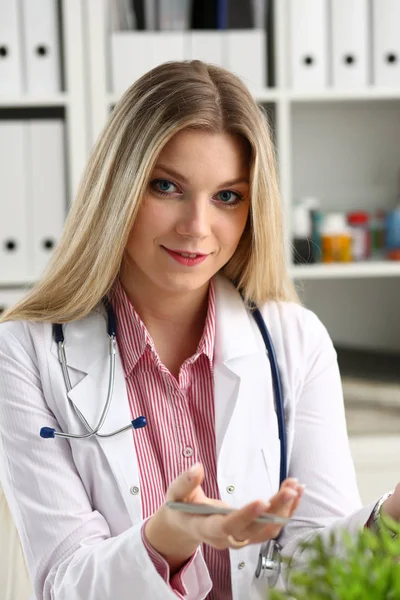 Bonita sorridente médico feminino sentar no local de trabalho — Fotografia de Stock