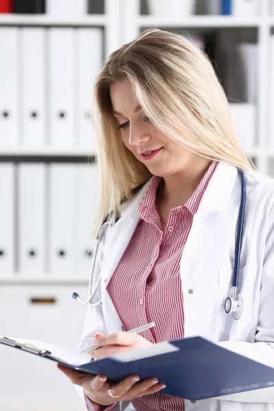 Szép női orvos mosolyogva tartsa csipeszes írótábla — Stock Fotó