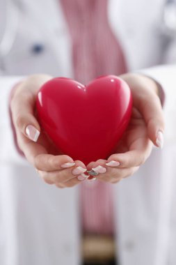 Kadın doktor kollarında tutun ve kırmızı oyuncak kapak