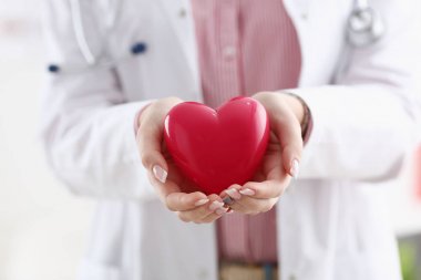 Kadın doktor kollarında tutun ve kırmızı oyuncak kapak