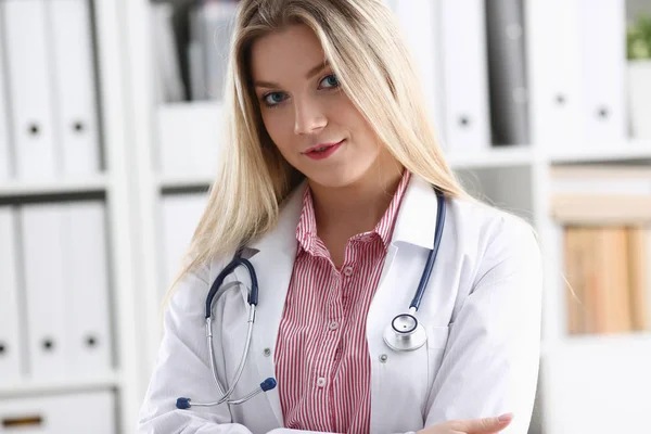 Bonita sorridente médico feminino sentar no local de trabalho — Fotografia de Stock