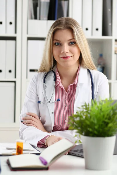 Vackra leende kvinnliga läkare, sitta på arbetsplatsen — Stockfoto