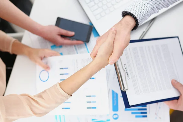 Man in suit shake hand as hello in office closeup