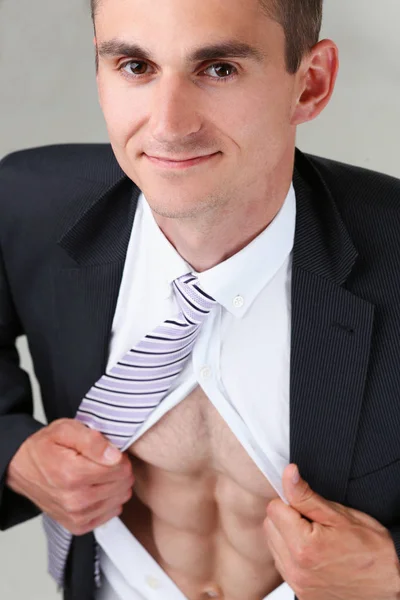 Mies solmio repiä vaatteita pois vartalon osoittaa abs — kuvapankkivalokuva