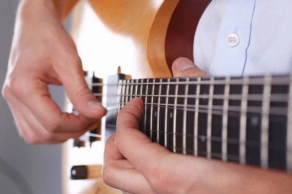 Male arms playing classic shape electric guitar — Stock Photo, Image