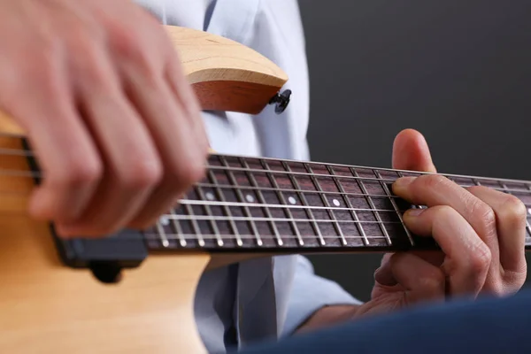 Male arms playing classic shape electric guitar