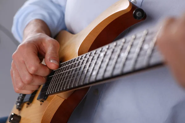 Male arms playing classic shape electric guitar