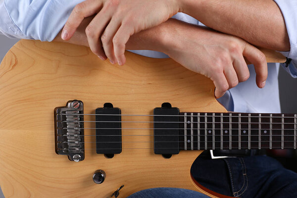 Male arms playing classic shape electric guitar