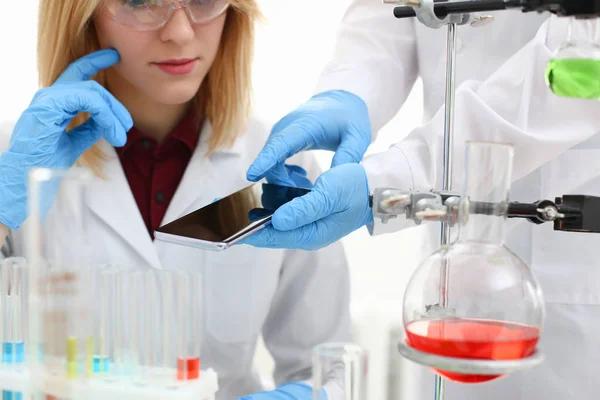 A female doctor in a chemical laboratory holds — Stock Photo, Image