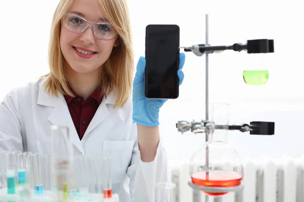 A female doctor in a chemical laboratory holds — Stock Photo, Image