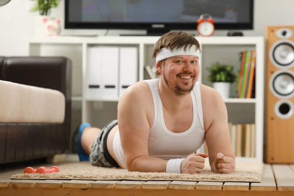 Young attractive fitness man lies on a fat mat with