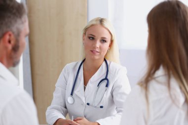 Kadın aile doktoru dikkatle genç dinle