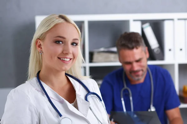 Красивая улыбающаяся женщина-врач стоит в кабинете — стоковое фото