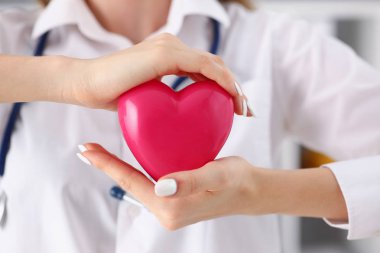 Kadın doktor kollarında tutun ve kırmızı oyuncak kapak