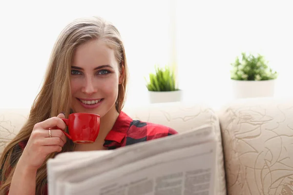 Donna bere caffè e lettura sedersi sul divano — Foto Stock