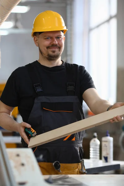 Portret van een lachende timmerman met houten planken — Stockfoto