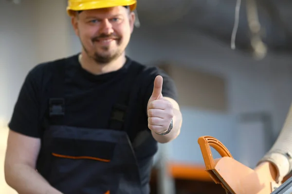 Trabajador sonriente en casco amarillo mostrar signo de confirmación — Foto de Stock