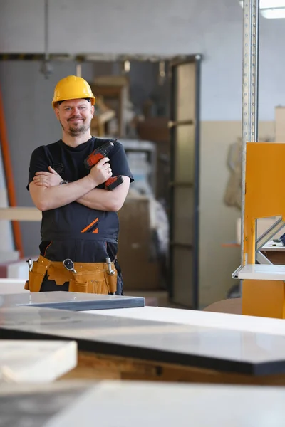 Takken van de werknemer met behulp van elektrische boor closeup — Stockfoto