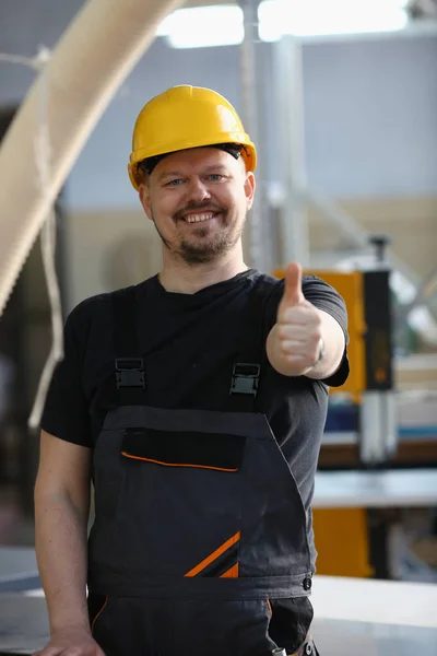 Glimlachend werknemer in gele helm Toon teken bevestigen — Stockfoto