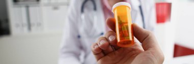 Erkek doktor el hapları kavanozunu tutuyor.