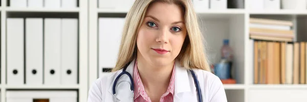 Vackra leende kvinnliga läkare, sitta på arbetsplatsen — Stockfoto