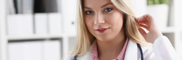 Bella sorridente medico femminile sedersi sul posto di lavoro — Foto Stock